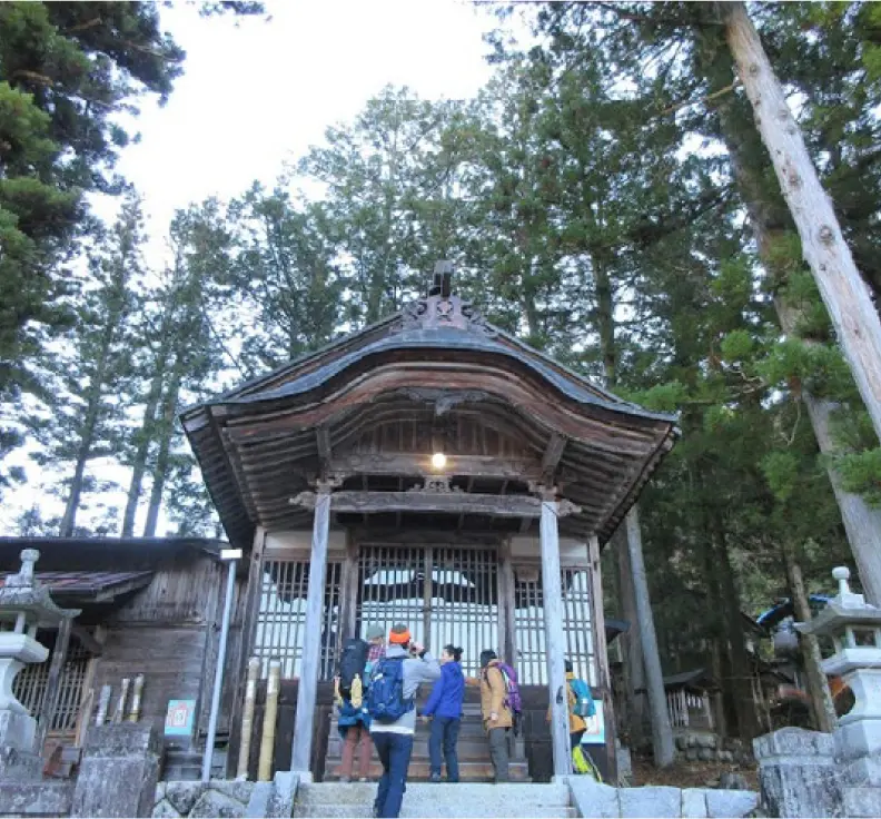 Five foreigners taking photos in front of a shrine