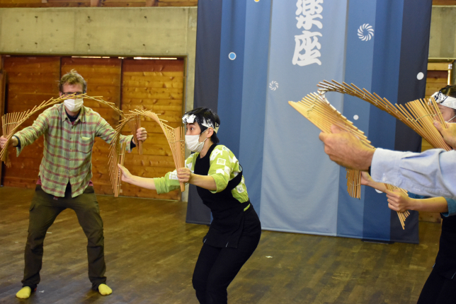 Participants engaging in a hands-on bamboo craft workshop, following the instructor’s guidance.