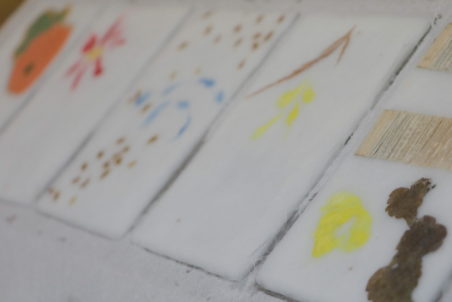 Handmade washi paper sheets with colorful hand-painted designs, showcasing the artistry and uniqueness of traditional papermaking.